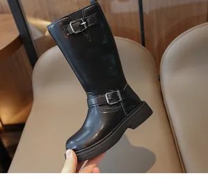 Detailed shot of girls black leather mid-calf boots featuring silver buckle straps and thick soles