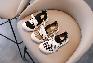 Detailed view of children canvas sneakers in black, khaki plaid and checkerboard patterns