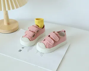 Détail de chaussures en toile rose pour enfant avec double bande velcro et bout en caoutchouc