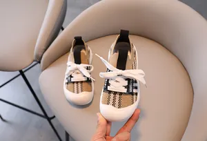 Close-up of children chunky sneakers with vintage check pattern and knit upper