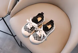 Close-up of kids checkered sneakers featuring a rubber toe cap and knit texture