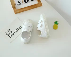 Détail des baskets en toile blanches pour enfants avec Velcro et embout de protection