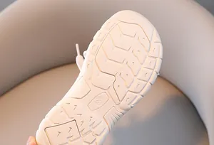 Detailed macro view of white non-slip wave patterns and size 28 on child shoe sole