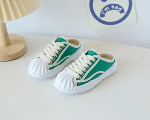 Detail of green canvas mule sneakers with white shell toe and thick rubber soles
