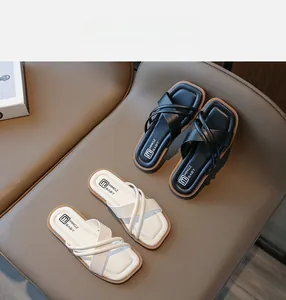 Draufsicht auf klassische schwarze und cremeweiße Kindersandalen mit gekreuztem PU-Leder