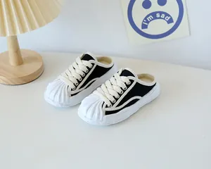 Detail view of children's canvas mule sneakers with rubber toe cap and slip-on design