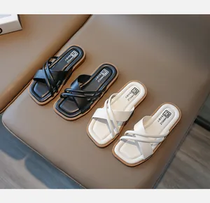 Draufsicht auf schwarz-weiße Mädchen-Sandalen mit Kreuzriemen und weicher Gummisohle