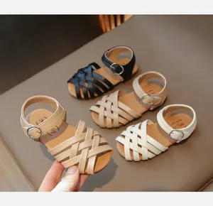 Détail des lanières en cuir tressé et boucles réglables sur ces sandales pour enfants