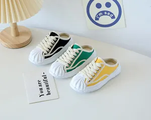 Detailed view of children's canvas mule sneakers in black, green and yellow colors