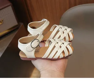 Détail de sandales en cuir tressé beige pour filles avec boucle métallique réglable