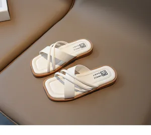 Details der cremefarbenen Kunstlederriemen und quadratischen Sohle bei Kindersandalen