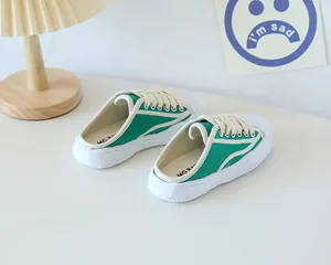 Detail view of children's green canvas mule shoes with thick white rubber soles