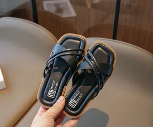 Nahaufnahme der Kindersandalen mit schwarzen Kreuzriemen und bequemen braunen Sohlen