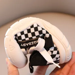 Flexible kids checkerboard sneakers with soft white rubber sole showing easy bending motion