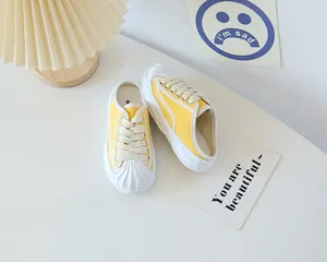 Detail view of yellow canvas mule sneakers with shell toe and chunky melt texture sole