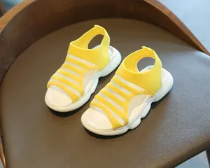 Detail of yellow knit toddler sandals with breathable mesh and white foam soles