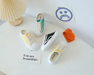 Kids slip-on canvas sneakers in green, yellow, and black with protective shell toe caps