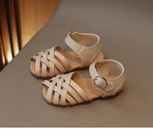 Détail de la tige tissée en similicuir beige et de la bride velcro pour sandales enfant