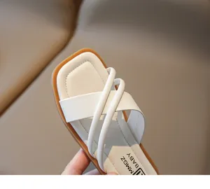 Details der cremeweißen Riemen und der flexiblen Gummisohle dieser Baby-Sandalen