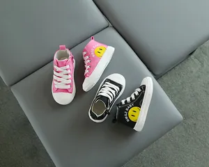 Dettaglio di sneaker alte per bambini con cerniere laterali e stampe smiley gialle