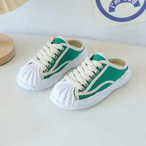 Green canvas slip-on sneakers for kids featuring white shell toe and thick rubber soles