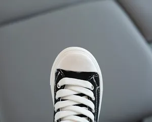 Dettaglio della punta in gomma bianca e tela nera di queste sneakers alte in stile classico