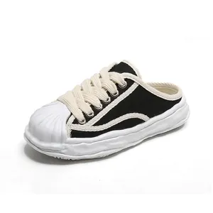 Classic black kids' canvas mule shoes with white shell toe and thick wavy sole