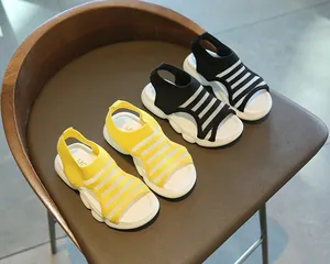 Detail of girls knit summer sandals in yellow and black with cushioned wavy white soles