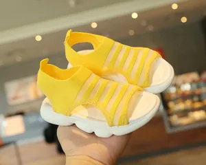 Close-up of yellow knit girls' sandals with thick white soles showing soft flexibility
