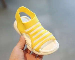 Close-up of girls' yellow knit sports sandals with a white wavy platform sole