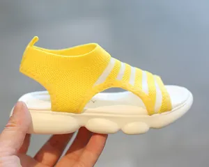 Detail view of yellow knitted girls sandals with stripe texture and thick white cloud sole