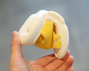 Detail showing the flexible and soft sole of yellow mesh sandals for toddler girls