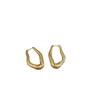 Minimalist irregular geometric earrings in matte gold with molten metal lava texture