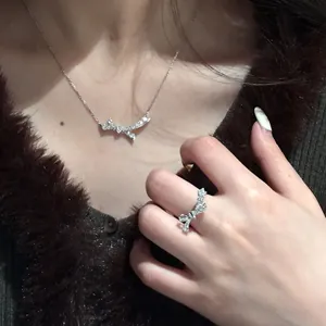 Close-up of sparkling zircon bow necklace and ring set worn on a model's neck