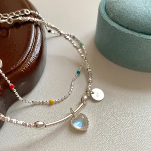 Detalle de pulsera de plata S925 con cuentas de colores y colgante de piedra de luna