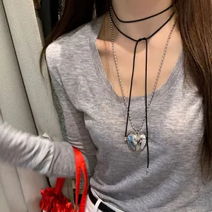 Détail du choker noir avec chaîne à billes argentées et pendentif cœur 3D réfléchissant