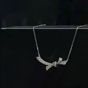 Detailed view of silver bow necklace with pavé cubic zirconia on black jewelry box