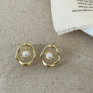 Vue détaillée de la boucle d'oreille dorée irrégulière avec une perle blanche ronde