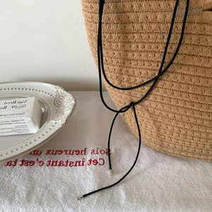 Détail d'un ras-de-cou en cordon noir minimaliste avec embouts métalliques argentés