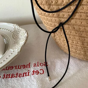 Sac en paille tressée avec cordons en velours noir et embouts métalliques argentés