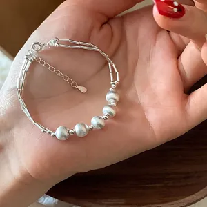 Detail of silver beaded bracelet with matte finish round beads and tubular segments