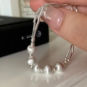 Minimalist silver beaded bracelet with brushed texture and polished double-row metal design