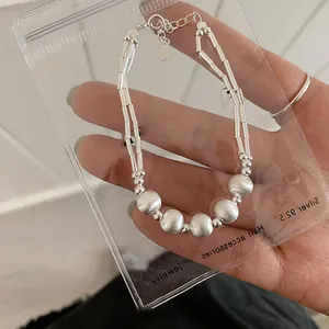 Close-up of matte silver beaded bracelet with adjustable chain and lobster clasp