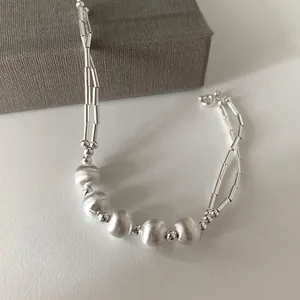 Elegant silver beaded bracelet featuring frosted round beads and sleek metal tubes