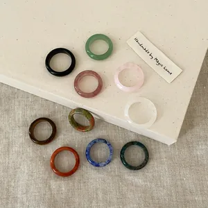 Flat lay of handmade natural stone ring set in diverse bohemian textures and colors