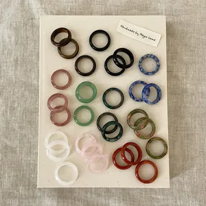 Minimalist natural crystal stone rings collection in assorted colors on linen background