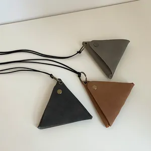 Detail view of retro triangle leather pouches in gray and brown with metal snap buttons