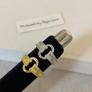 Détails de bagues à boucle en métal brossé avec pavé de zircones sur supports noirs