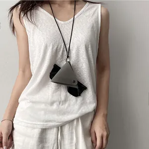 Minimalist grey triangle leather glasses holder necklace with sunglasses on white linen vest