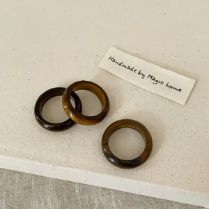 Macro detail of three handmade tiger eye stone rings with natural brown marble textures